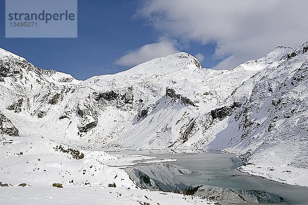 Stausee Naßfeld auf 2233 m an der Großglockner Hochalpenstraße mit verschneiten Bergen  Kapuziner 2852 m  Schartenkopf 2857 m und Untere Pfandlscharte  Nationalpark Hohe Tauern  Kärnten  Österreich  Europa