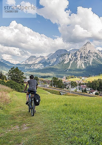 Radfahrer auf Radtour mit Mountainbike  auf dem Radweg Via Claudia Augusta  im Rücken Ehrwalder Sonnenspitze  Alpenüberquerung  Berglandschaft  Alpen  Ehrwalder Becken  bei Ehrwald  Tirol  Österreich  Europa