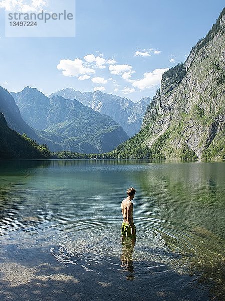 Junger Mann badet im Obersee  hinter Watzmannmassiv  Salet am Königssee  Nationalpark Berchtesgaden  Berchtesgadener Land  Oberbayern  Bayern  Deutschland  Europa