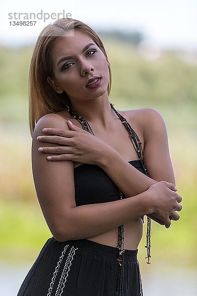 Porträt einer jungen Frau in einem schwarzen Sommerkleid