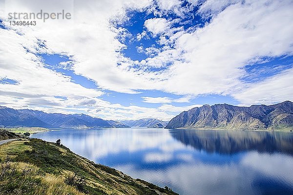 Bewölkter Himmel mit Wasserreflexionen im Hawea-See  Haast Pass  Südinsel  Neuseeland  Ozeanien