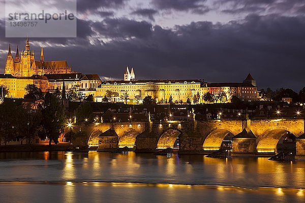 Beleuchtete Karlsbrücke mit Prager Burg und Veitsdom am Abend  Wolkenstimmung  Prag  Tschechische Republik  Europa