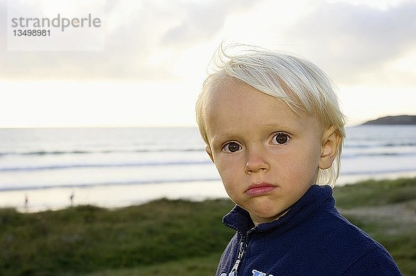 Kleiner Junge steht selbstbewusst auf einer Düne am Meer  Bretagne  Frankreich  Europa