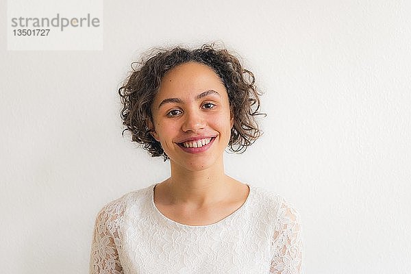Porträt einer jungen lächelnden Frau vor einem weißen Hintergrund  Deutschland  Europa