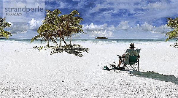 Mann mit Sonnenhut auf einem Stuhl sitzend an einem Strand in der Karibik bei Punta Allen  Mexiko  Nordamerika  Mittelamerika