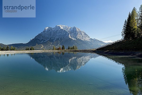 Wasserspeicher zur Beschneiung der Skipisten am Grubigstein mit Blick auf die Zugspitze und Bergbahn  Lermoos  Tirol  Österreich  Europa