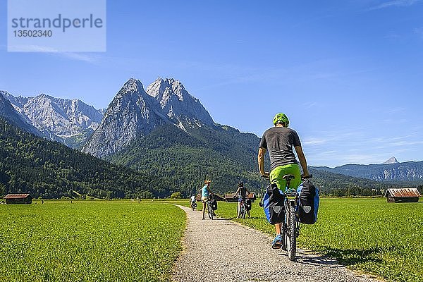 Radfahrer auf Radtour fährt auf Radweg auf seinem Mountainbike  hinten Zugspitze  Tegernauweg  bei Grainau  Alpenüberquerung  Garmisch-Partenkirchen  Oberbayern  Bayern  Deutschland  Europa
