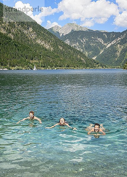 Drei Personen beim Baden im Plansee  Blick vom Ufer  türkisfarbenes Wasser  Bergsee  Berglandschaft  Tiroler Alpen  Reutte  Tirol  Österreich  Europa