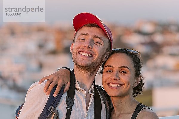 Junge Frau und junger Mann schauen fröhlich in die Kamera  Paar  Plaza de la Encarnacion  Sevilla  Andalusien  Spanien  Europa