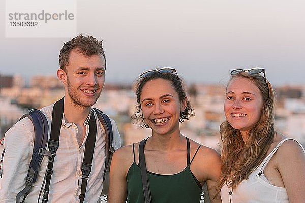 Zwei junge Frauen und ein junger Mann schauen in die Kamera  Freunde  Plaza de la Encarnacion  Sevilla  Andalusien  Spanien  Europa