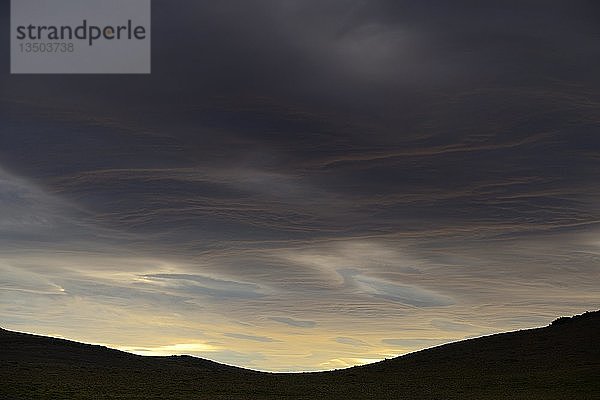 Dramatischer Sonnenuntergang mit aufziehenden Gewitterwolken vor Bergsilhouette  Pali Aike National Park  Provinz Magallanes  Chile  Südamerika