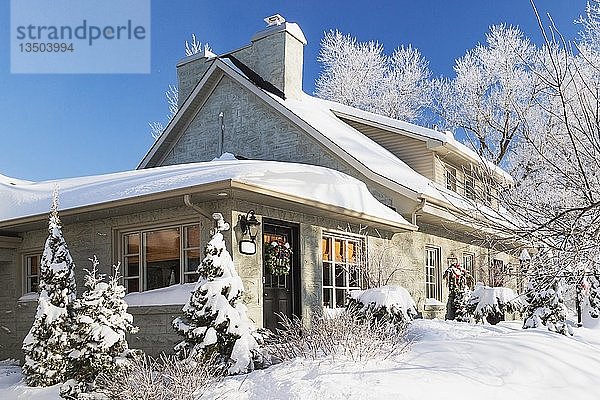 Alte Hausfassade aus den 1840er Jahren mit grauem Steinmauerwerk und Holzverkleidung sowie Weihnachtsschmuck im Winter  Quebec  Kanada  Nordamerika