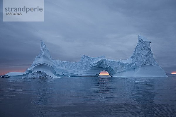 Blauer Eisberg mit Tor nach Sonnenuntergang  in der Nähe der Appat-Insel  Grönland  Nordamerika