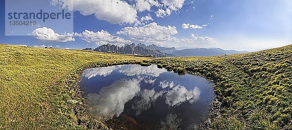 Wolken  die sich in einem Teich auf der Aferer Alm am Plosen spiegeln  Blick auf das Aferer Geislermassiv und den Peitlerkofel  Würzjochkamm  Villnösstal  Dolomiten  Provinz Bozen  Italien  Europa