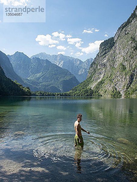 Junger Mann badet im Obersee  hinter Watzmannmassiv  Salet am Königssee  Nationalpark Berchtesgaden  Berchtesgadener Land  Oberbayern  Bayern  Deutschland  Europa