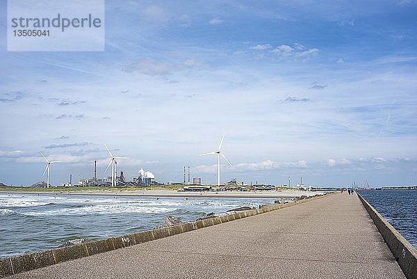 Damm an der Nordseeküste bei Wijk aan Zee  im Hintergrund Windmühlen und das Stahlwerk Tata  Ijmuiden  Nordholland  Niederlande