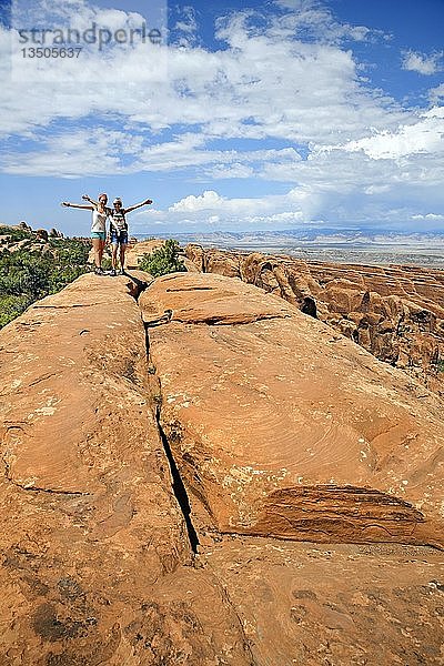 Wanderer balancieren auf einem Sandsteinfelsen im Devil's Garden  Arches-Nationalpark  bei Moab  Utah  Vereinigte Staaten  Nordamerika