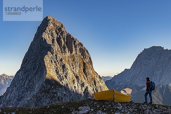 Gipfel der Sonnenspitze mit Bergsteiger und Zelt sowie der Zugspitze im Hintergrund  Ehrwald  AuÃŸerfern  Tirol  Ã-sterreich  Europa