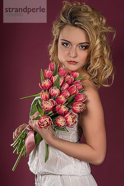 Junge Frau posiert mit Blumenstrauß  Tulpen  Mode  Lifestyle  Porträt
