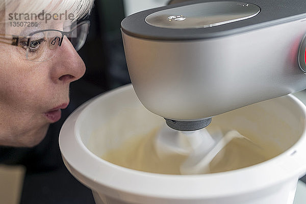 Eine Frau schaut mit großen Augen auf ihre Küchenmaschine  Deutschland  Europa