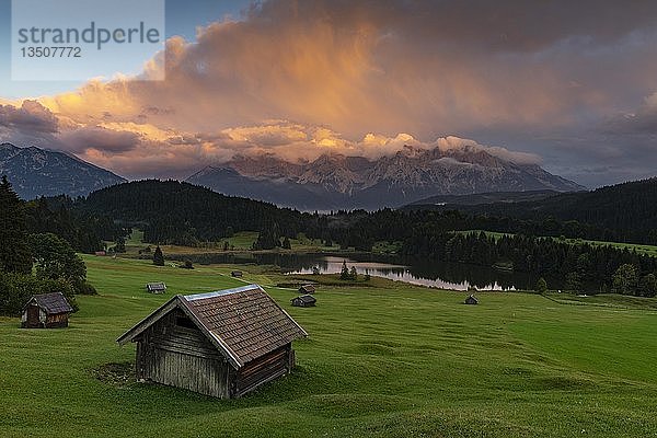 Kleine Hütte auf Bergwiese mit Geroldsee  im Hintergrund Karwendelgebirge mit dramatischem Wolkenhimmel  Gerold  Mittenwald  Bayern  Deutschland  Europa
