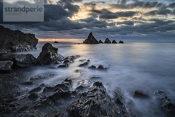 Zerklüftete Küste bei Sonnenuntergang  Felsen im Meer  Wolkenstimmung  Greymouth  Westküste  Südinsel  Neuseeland  Ozeanien