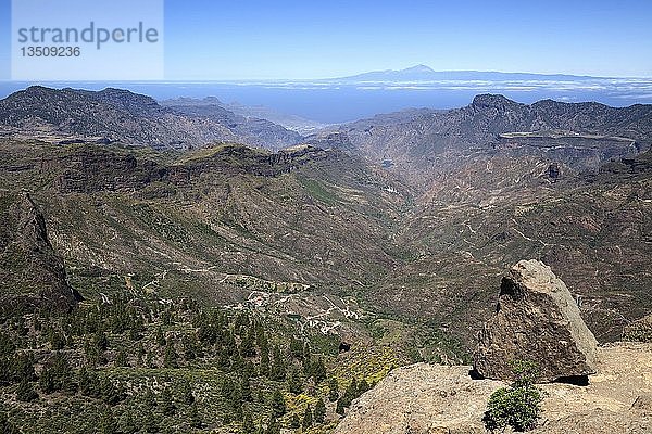 Blick vom Roque Nublo  Kultfelsen der Kanaren  in den Barranco del Chorrillo und die Berge im Westen von Gran Canaria  hinter Teneriffa mit Vulkan Teide  rechts Altavista  Gran Canaria  Kanarische Inseln  Spanien  Europa
