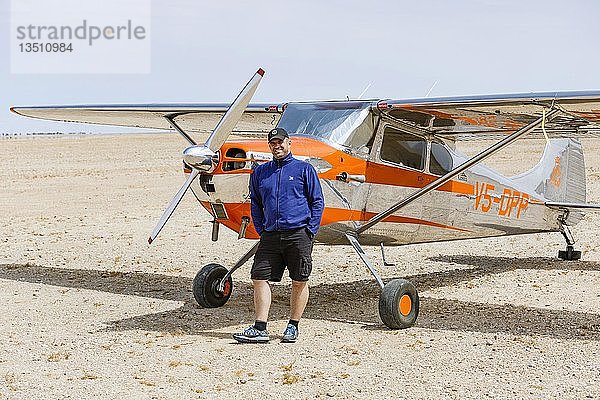 Mann lehnt an Cessna 170  Flugplatz Ganab  Namib Naukluft National Park  Erongo Region  Namibia  Afrika