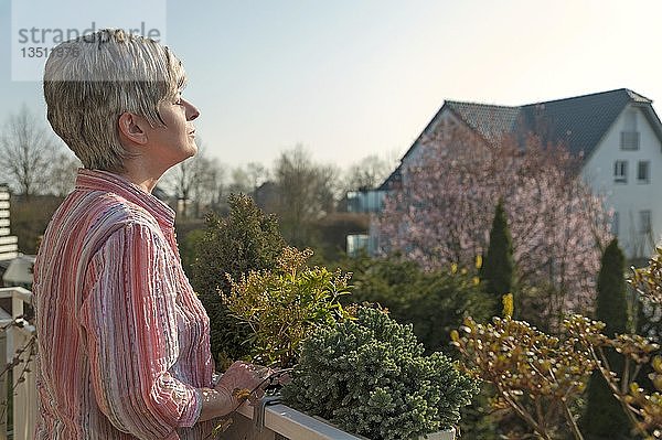 Frau steht auf einem Balkon und genießt die Morgensonne  Grevenbroich  Nordrhein-Westfalen  Deutschland  Europa