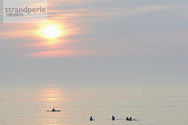 Silhouettten  Surfer und Seekajakfahrer auf der ruhigen Nordsee am Abend  Norderney  Ostfriesische Inseln  Niedersachsen  Deutschland  Europa