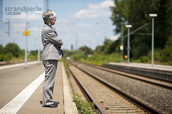 Frau  50+  wartet an einem verlassenen Bahnsteig