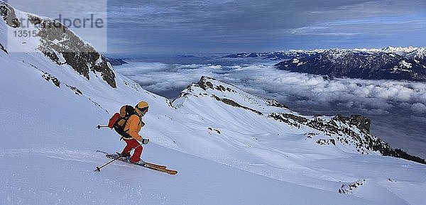 Skitour  Skifahrerin bei der Abfahrt vom Alvier  Nebel über dem Rheintal  Alviergruppe  Appenzeller Alpen  Kanton St. Gallen  Schweiz  Europa