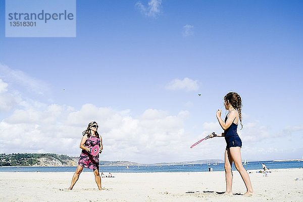 Mutter und Tochter spielen am Strand Schläger und Ball  Morgat  Bretagne  Frankreich  Europa