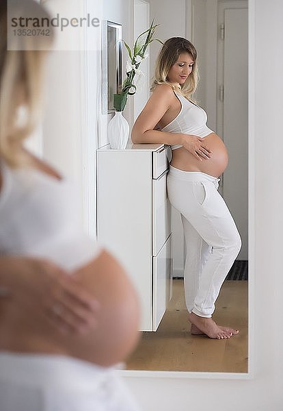 Frau im neunten Monat schwanger  betrachtet sich im Spiegel  Deutschland  Europa
