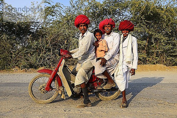 Vier Männer aus drei Generationen fahren gemeinsam auf einem Motorrad  Rajasthan  Indien  Asien