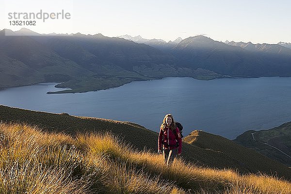 Wanderin am Isthmus Peak  Lake Wanaka und Bergpanorama bei stimmungsvollem Abendlicht  Otago  Südinsel  Neuseeland  Ozeanien