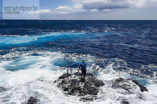 Fischer auf einem Felsen im Meer stehend mit seinen Angelruten  Kalae  South Point  Big Island  Hawaii  USA  Nordamerika