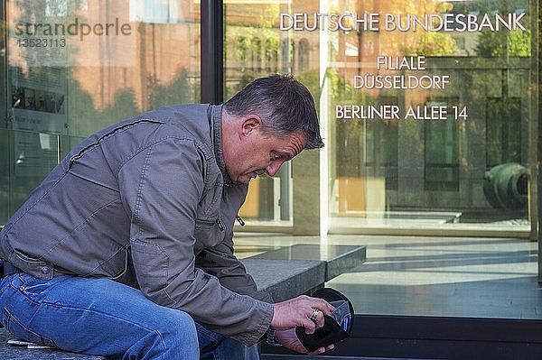 Besorgter Mann schaut in seine Brieftasche  Düsseldorf  Nordrhein-Westfalen  Deutschland  Europa