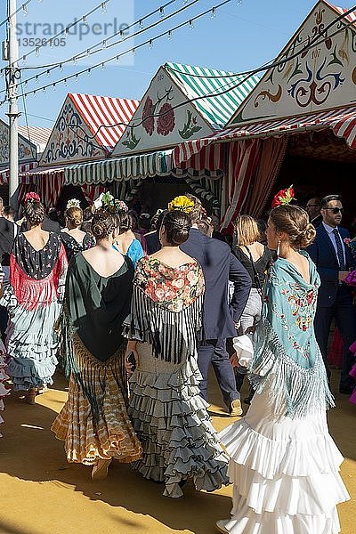 Spanische Frauen mit bunten Flamenco-Kleidern vor Festzelten  Casetas  Feria de Abril  Sevilla  Andalusien  Spanien  Europa