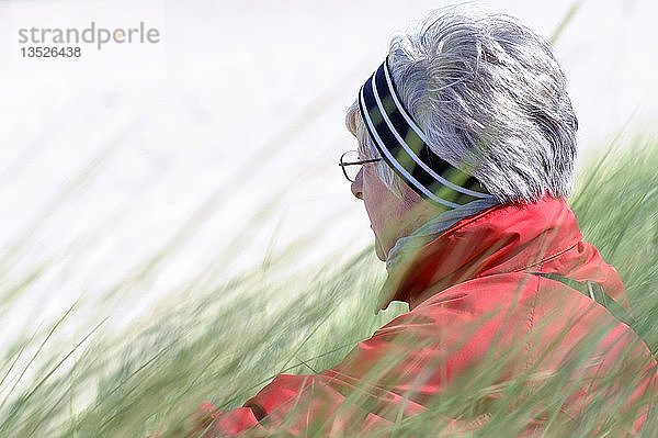 Frau sitzt im Strandhafer auf den Dünen der Ostseeküste  Mecklenburg-Vorpommern  Deutschland  Europa