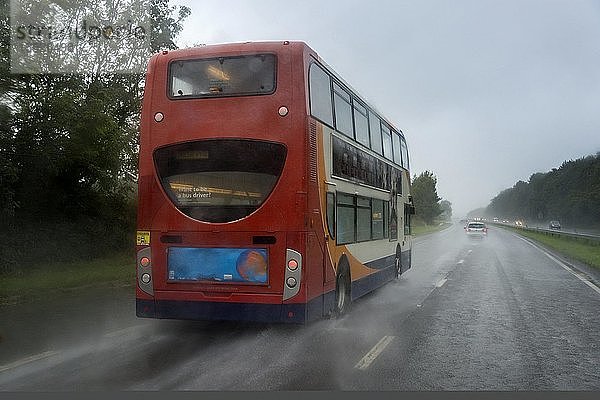 Roter Bus im Regen auf der Landstraße  Cornwall  England  Vereinigtes Königreich  Europa
