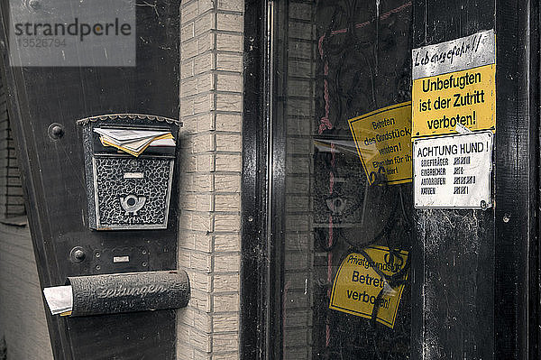 Verschlossene Haustür mit Verbotsschildern und einem überquellenden Briefkasten  Borschemich  Nordrhein-Westfalen  Deutschland  Europa