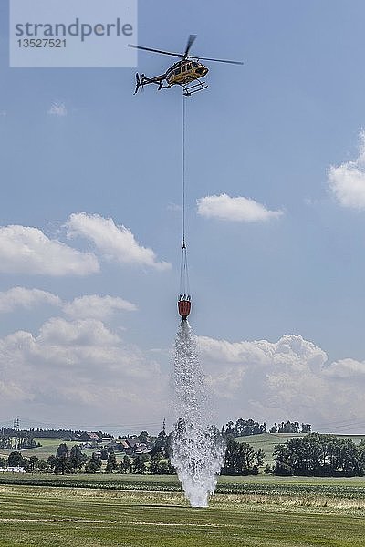 Hubschrauber leert Wassertank für punktgenaues Löschen von Bränden  Übung  Schweiz  Europa