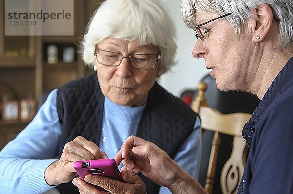 Zwei ältere Frauen mit einem Smartphone  Grevenbroich  Nordrhein-Westfalen  Deutschland  Europa