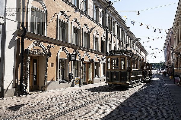 Straßenbahn fährt durch eine Häuserreihe  Helsinki  Finnland  Europa