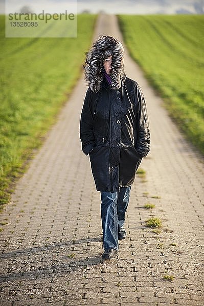 Frau geht auf einem Feldweg  Grevenbroich  Nordrhein-Westfalen  Deutschland  Europa