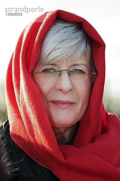 Portrait einer Frau mit rotem Schal um den Kopf