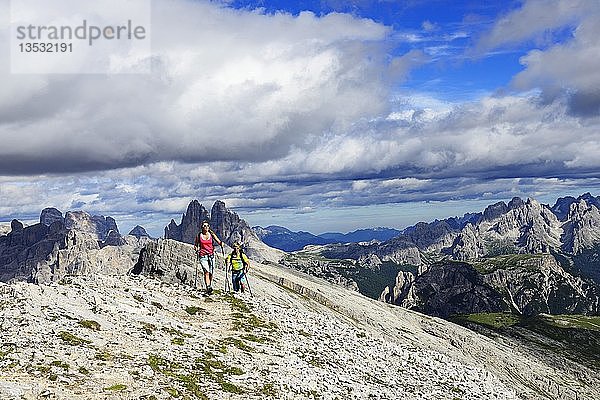 Wanderer beim Aufstieg von der Plätzwiese zum Gipfel des Dürrensteins  im Hintergrund der Monte Cristallo und die Drei Zinnen von Lavaredo  Sextner Dolomiten  Hochpustertal  Südtirol  Italien  Europa
