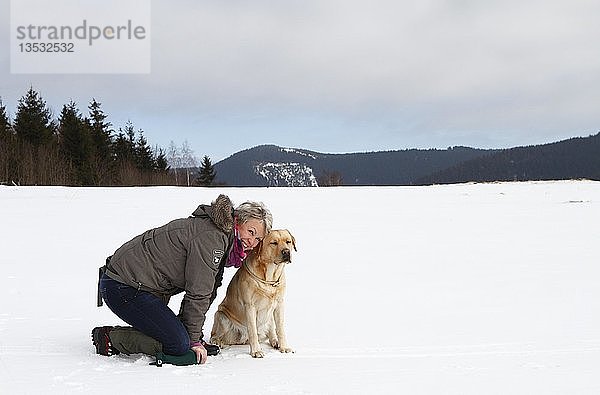 Frau mit Golden Retriever kniend im Schnee  Thüringen  Deutschland  Europa