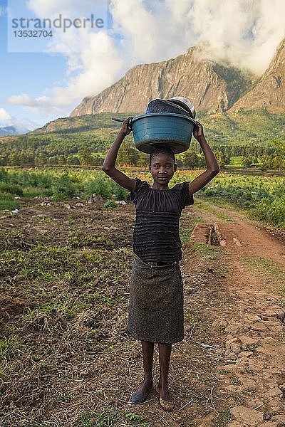 Mädchen mit abgewaschenem Geschirr vor dem Berg Mulanje  Malawi  Afrika